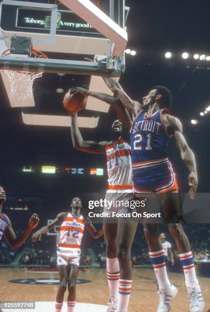 Dave Bing of the Detroit Pistons leaps to defend the shot of Elvin Hayes of the Washington Bullets during an NBA basketball game circa 1975 at the...