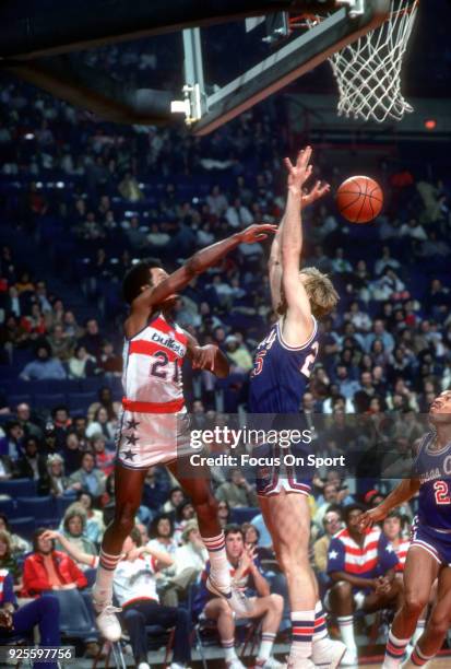 Dave Bing of the Washington Bullets passes the ball over the top of Jim Eakins of the Kansas City Kings during an NBA basketball game circa 1976 at...