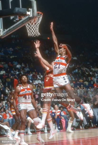 Dave Bing of the Washington Bullets leaps to defend the shot of Bingo Smith of the Cleveland Cavaliers during an NBA basketball game circa 1976 at...