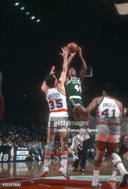 Dave Bing of the Boston Celtics shoots over Kevin Grevey of the Washington Bullets during an NBA basketball game circa 1977 at the Capital Centre in...