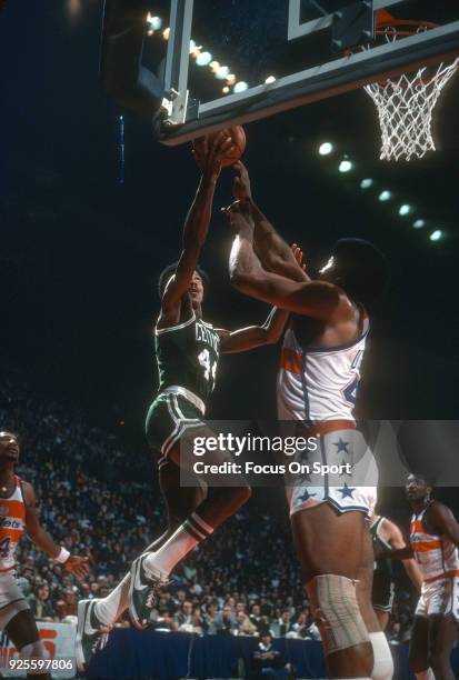 Dave Bing of the Boston Celtics goes in for a layup over Wes Unseld of the Washington Bullets during an NBA basketball game circa 1977 at the Capital...