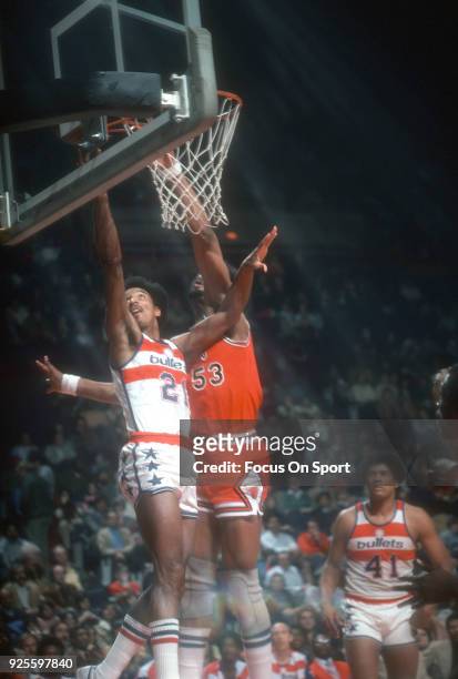 Dave Bing of the Washington Bullets goes in for a layup over Artis Gilmore of the Chicago Bulls during an NBA basketball game circa 1975 at the...