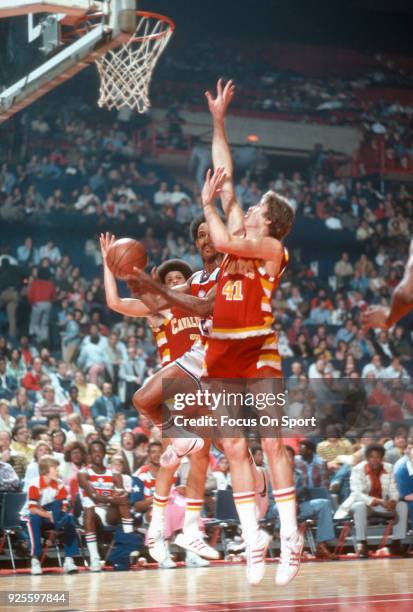 Dave Bing of the Washington Bullets looks to get his shot off over Eric Fernsten and Bingo Smith of the Cleveland Cavaliers during an NBA basketball...