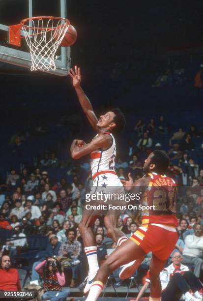 Dave Bing of the Washington Bullets goes in for a layup over Campy Russell of the Cleveland Cavaliers during an NBA basketball game circa 1975 at the...