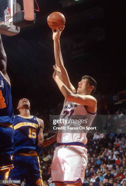 Gheorghe Muresan of the Washington Bullets shoots over Chris Webber and Latrell Sprewell of the Golden State Warriors during an NBA basketball game...