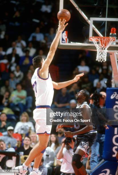 Gheorghe Muresan of the Washington Bullets shoots over Anthony Avent of the Orlando Magic during an NBA basketball game circa 1994 at the US Airways...