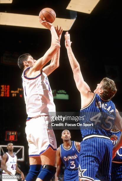 Gheorghe Muresan of the Washington Bullets shoots over Jon Koncak of the Orlando Magic during an NBA basketball game circa 1995 at the US Airways...