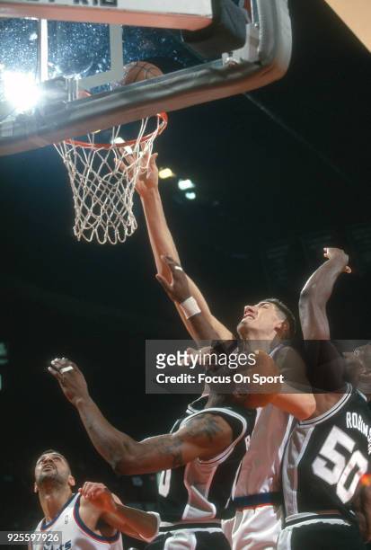 Gheorghe Muresan of the Washington Bullets shoots over Dennis Rodman and David Robinson of the San Antonio Spurs during an NBA basketball game circa...