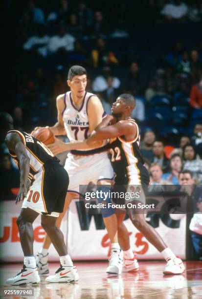 Gheorghe Muresan of the Washington Bullets backs in on Reggie Jordan of the Atlanta Hawks during an NBA basketball game circa 1995 at the US Airways...