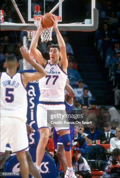 Gheorghe Muresan of the Washington Bullets looks to pass the ball against the Charlotte Hornets during an NBA basketball game circa 1995 at the US...