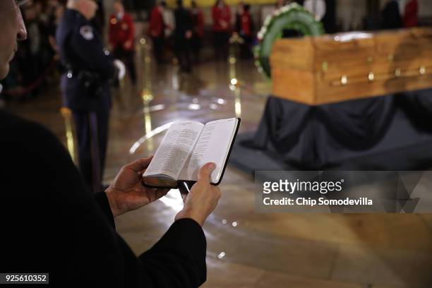 Man reads from the Bible as he pays respect to Christian evangelist and Southern Baptist minister Billy Graham as his body lays in honor in the U.S....