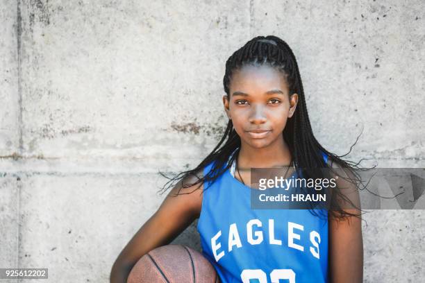 zuversichtlich weiblichen basketball-spieler mit ball - basketball sport stock-fotos und bilder