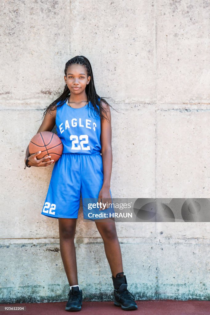 Jugadora de longitud completa con la bola contra la pared