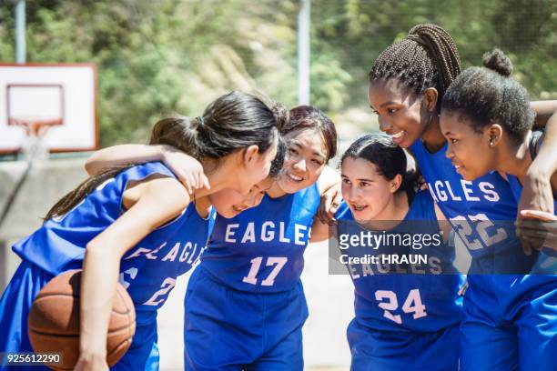 female basketball players huddling on court - basketball sport team stock pictures, royalty-free photos & images