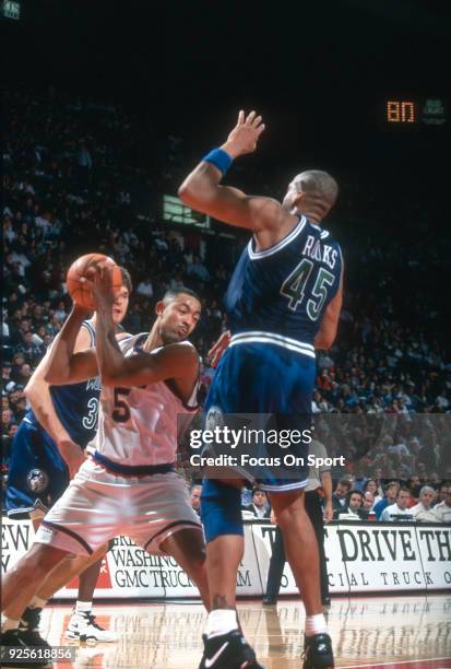 Juwan Howard of the Washington Bullets looks to put a move on Sean Rooks of the Minnesota Timberwolves during an NBA basketball game circa 1994 at...