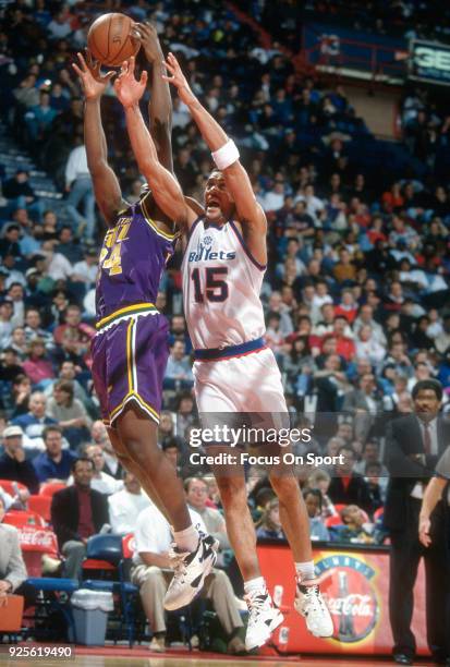 Kenny Walker of the Washington Bullets battles for a rebound with Bryon Russell of the Utah Jazz during an NBA basketball game circa 1993 at the US...