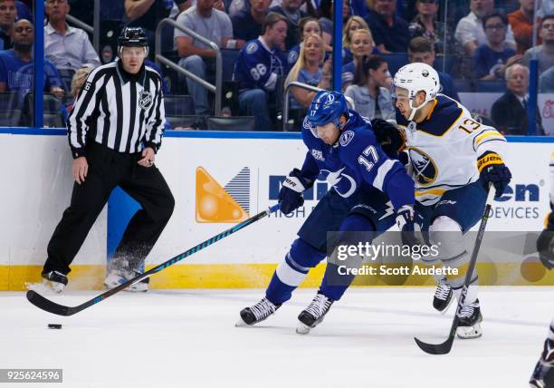 Alex Killorn of the Tampa Bay Lightning skates against Nicholas Baptiste of the Buffalo Sabres during the first period at Amalie Arena on February...