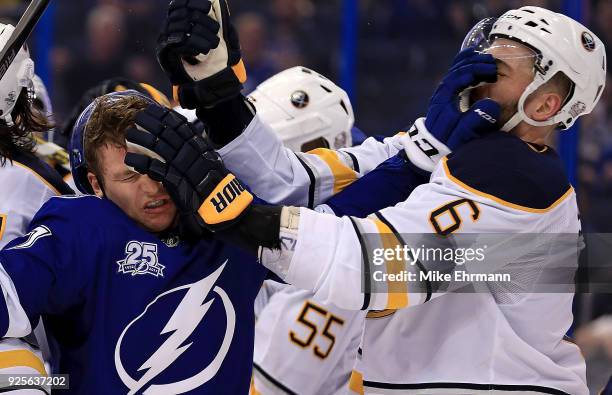 Yanni Gourde of the Tampa Bay Lightning and Marco Scandella of the Buffalo Sabres get in a fight during a game at Amalie Arena on February 28, 2018...