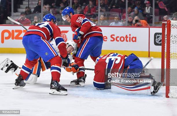 Antti Niemi of the Montreal Canadiens covers up the puck under pressure from Josh Bailey of the New York Islanders in the NHL game at the Bell Centre...