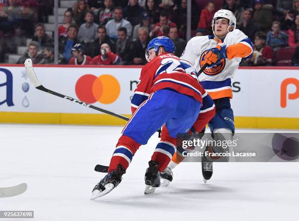 Karl Alzner of the Montreal Canadiens battles for position against Mathew Barzal of the New York Islanders in the NHL game at the Bell Centre on...
