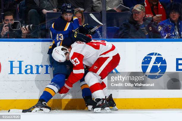 Jordan Schmaltz of the St. Louis Blues and Darren Helm of the Detroit Red Wings fight for control of the puck at Scottrade Center on February 28,...