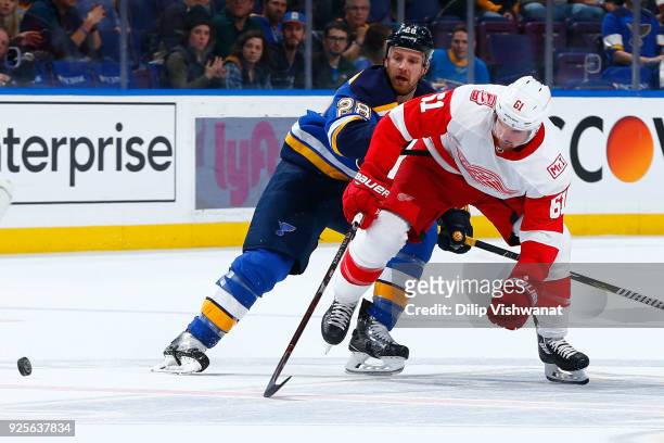 Xavier Ouellet of the Detroit Red Wings looses the puck against Kyle Brodziak of the St. Louis Blues at Scottrade Center on February 28, 2018 in St....