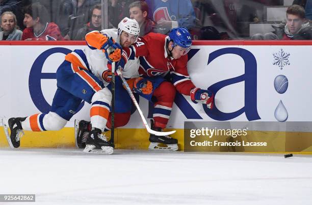 Adam Pelech of the New York Islanders tries to slow down Charles Hudon of the Montreal Canadiens in the NHL game at the Bell Centre on February 28,...