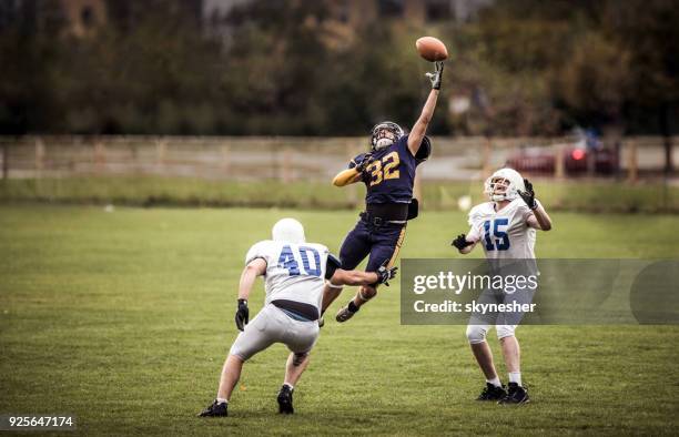 us-amerikanischer american-football-spiel auf den fang des balls! - football receiver stock-fotos und bilder