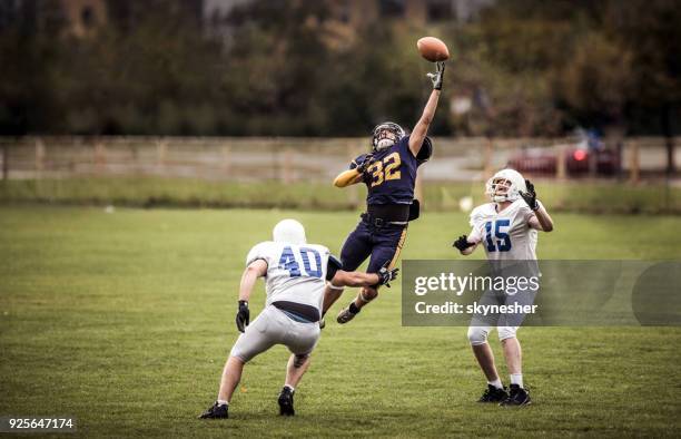 het vangen van de bal op american football wedstrijd! - quaterbacks stockfoto's en -beelden