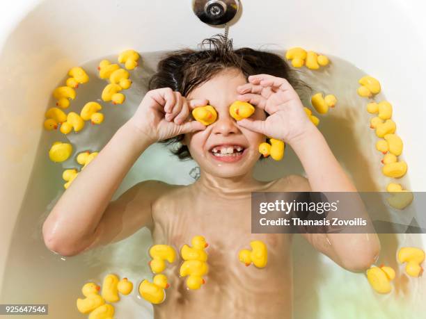 7 year old boy playing in the bathroom - boy taking a shower stock-fotos und bilder