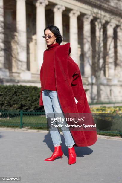 Eva Chen is seen on the street attending Maison Margiela during Paris Fashion Week Women's A/W 2018 Collection wearing a long red coat with matching...