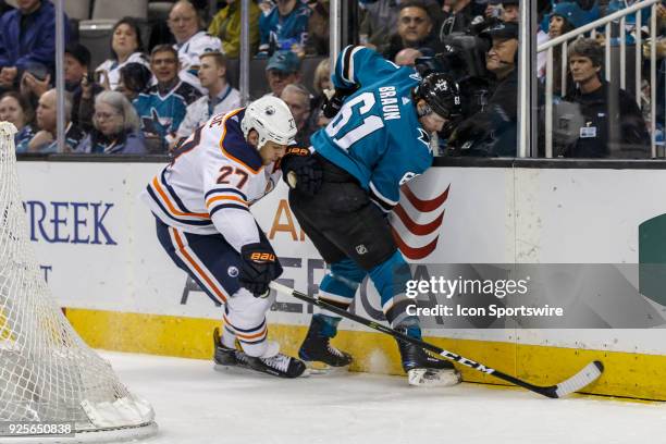 San Jose Sharks defenseman Justin Braun and Edmonton Oilers left wing Milan Lucic fight for the puck behind San Jose Sharks net during the first...