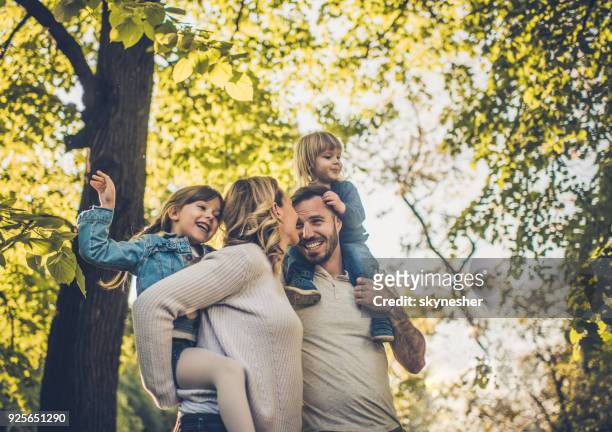 below view of carefree family having fun in spring day. - piggyback stock pictures, royalty-free photos & images