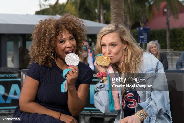 Tanika Ray and Jamie Anderson kiss Olympic medals together at "Extra" at Universal Studios Hollywood on February 28, 2018 in Universal City,...