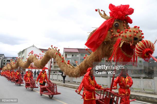 Folk artists push forward the 45-metre-long straw dragon with 13 red wheelbarrows while performing Baijiang Straw Dragon Dance to welcome the Lantern...