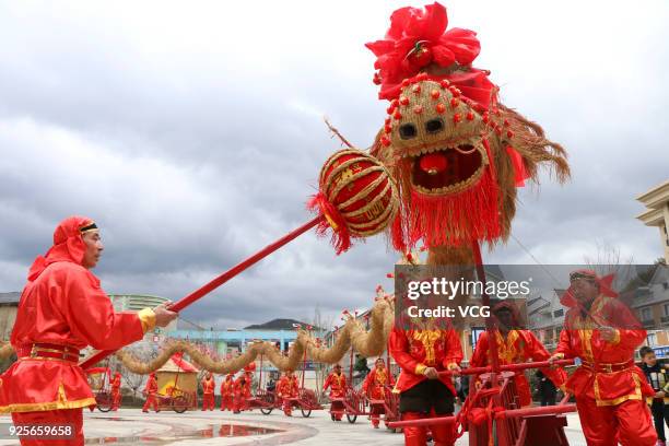 Folk artists push forward the 45-metre-long straw dragon with 13 red wheelbarrows while performing Baijiang Straw Dragon Dance to welcome the Lantern...