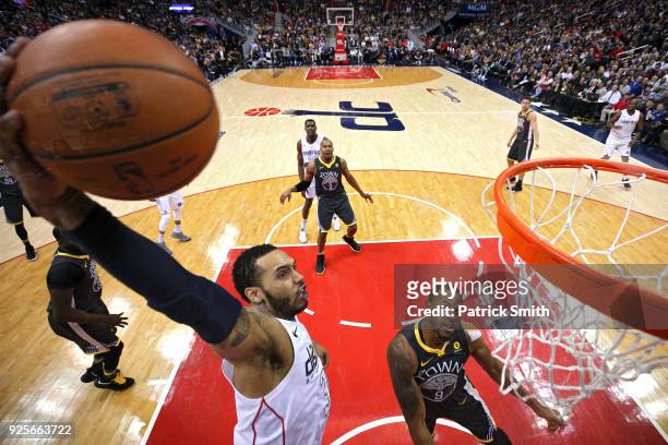 Mike Scott of the Washington Wizards dunks in front of Andre Iguodala of the Golden State Warriors during the first half at Capital One Arena on...
