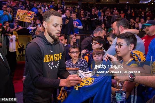 Stephen Curry of the Golden State Warriors signs an autograph for a fan prior to the game against the New York Knicks on February 26, 2018 at Madison...