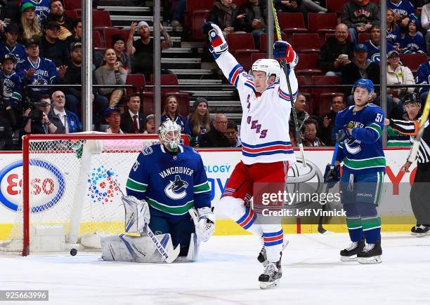 Troy Stecher and Jacob Markstrom of the Vancouver Canucks look on as Jimmy Vesey of the New York Rangers celebrates his goal during their NHL game at...