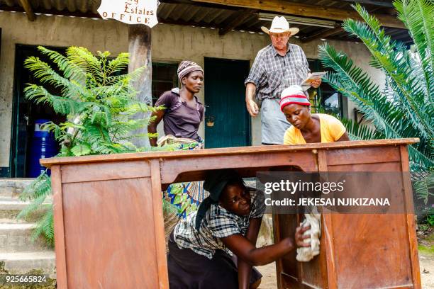 Mary Mhuriyengwe leads workers cleaning an abandoned and dusty office desk for Zimbabwean commercial farmer Rob Smart at Lesbury Estates in Headlands...
