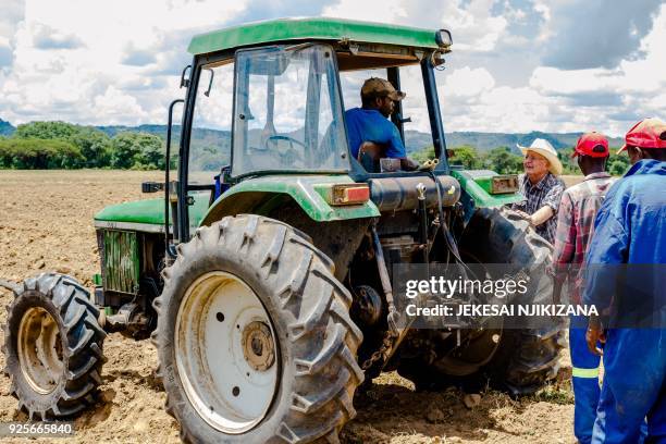 Zimbabwean commercial farmer Rob Smart interacts with his workers as they prepare land for a potato crop at Lesbury Estates farm in Headlands east of...