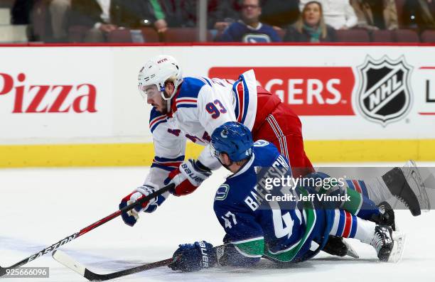 Sven Baertschi of the Vancouver Canucks checks Mika Zibanejad of the New York Rangers during their NHL game at Rogers Arena February 28, 2018 in...