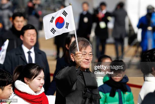 South Korean President Moon Jae-In waves the national flag during a march to commemorate the 99th Independence Movement Day ceremony at Seodaemun...