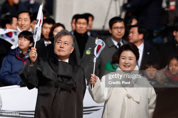 South Korean President Moon Jae-In and his wife Kim Jung-Sook wave the national flag during a march to commemorate the 99th Independence Movement Day...