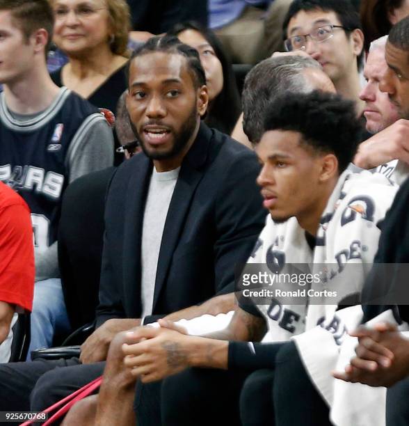 Kawhi Leonard of the San Antonio Spurs sits on the bench in street clothes during a game against the New Orleans Pelicans at AT&T Center on February...