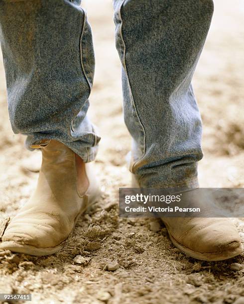 feet with jeans and boots - arbeitsstiefel stock-fotos und bilder