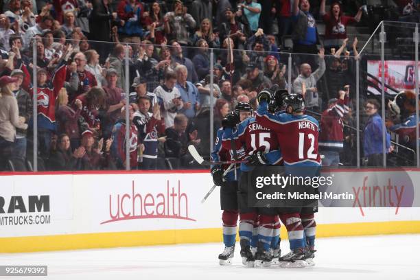 Duncan Siemens of the Colorado Avalanche celebrates his first career NHL goal against the Calgary Flames with teammates Patrik Nemeth and Nathan...