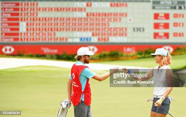 Michelle Wie of the United States and caddie react after finishing on the 18th green during round one of the HSBC Women's World Championship at...