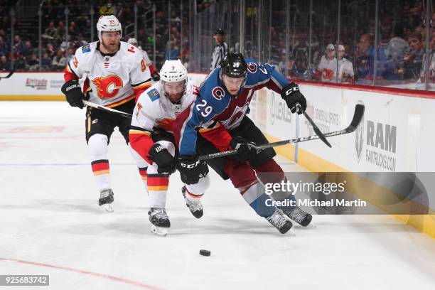 Nathan MacKinnon of the Colorado Avalanche fights for position against TJ Brodie of the Calgary Flames at the Pepsi Center on February 28, 2018 in...