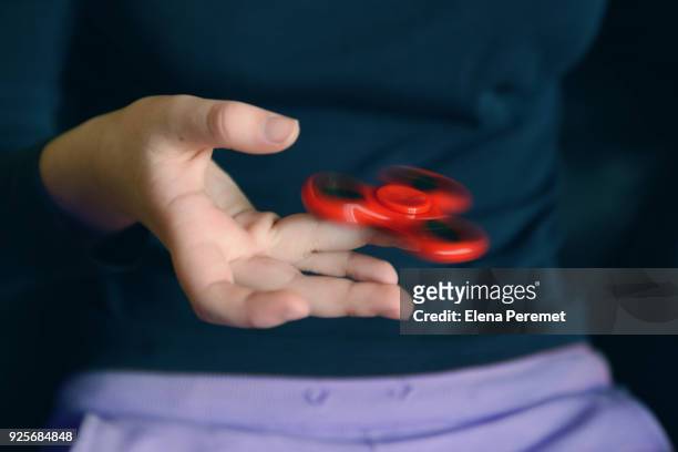cropped hand spinning fidget spinner - gegengift stock-fotos und bilder